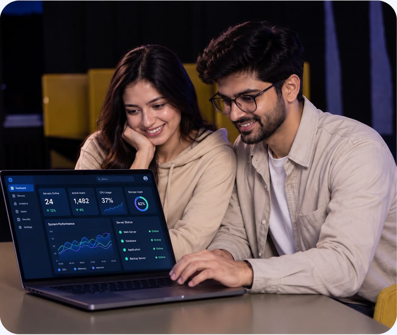 Two technology professionals reviewing a live system dashboard on a laptop